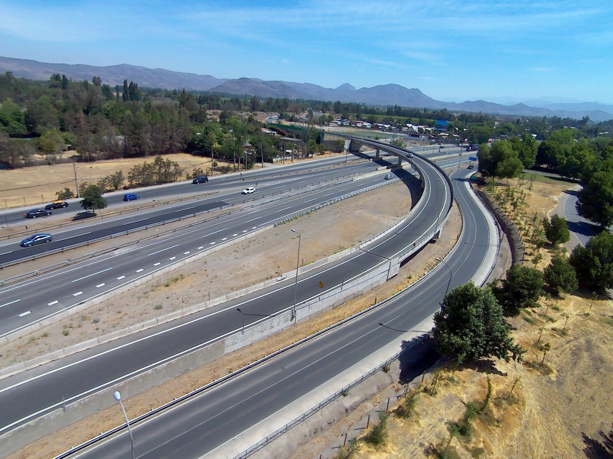Vista aérea de una ruta de doble calzada con enlace y viaducto, cordillera al fondo